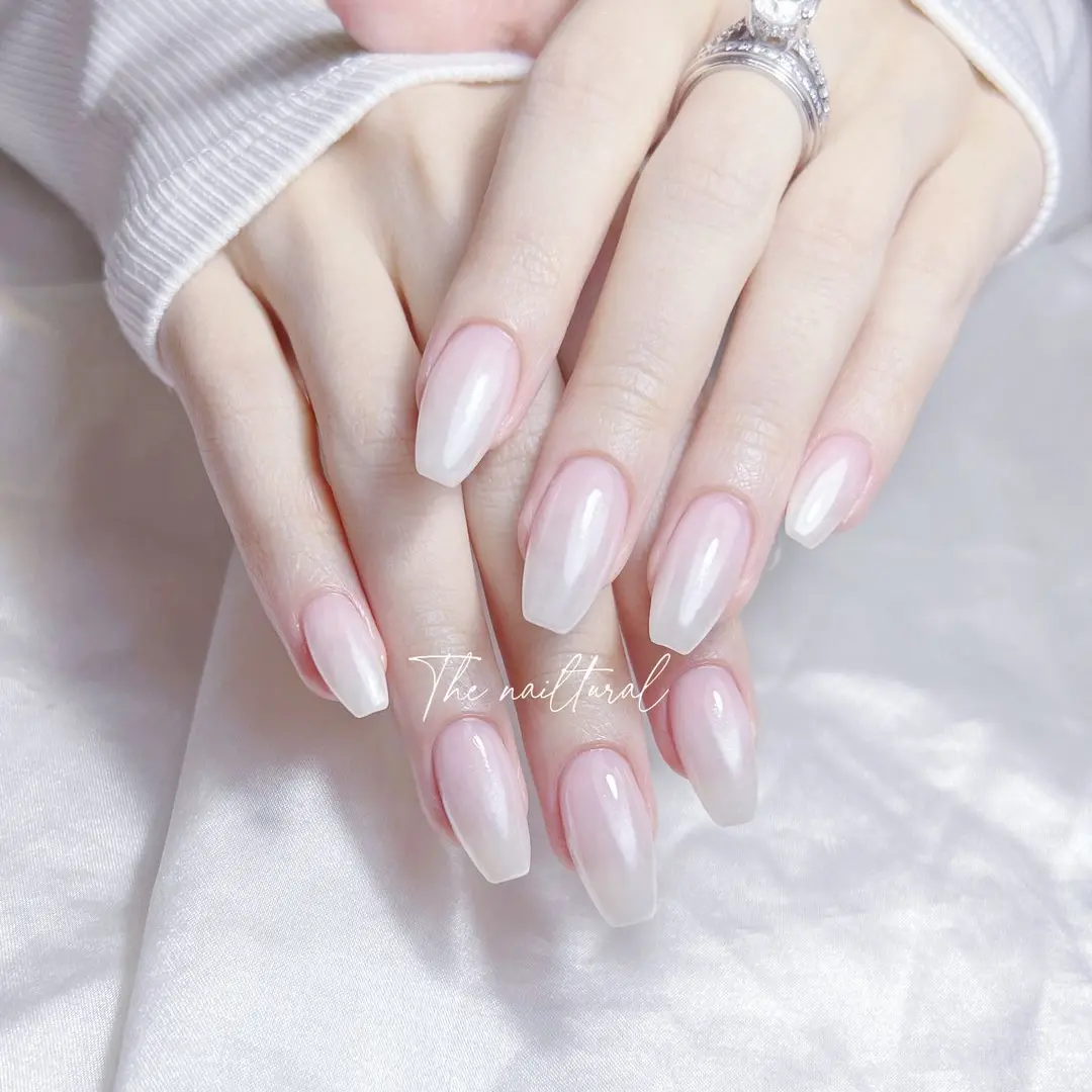lmond-shaped nails, manicured nails,  elegant,  sheer, pearlescent pearlescent white finish,