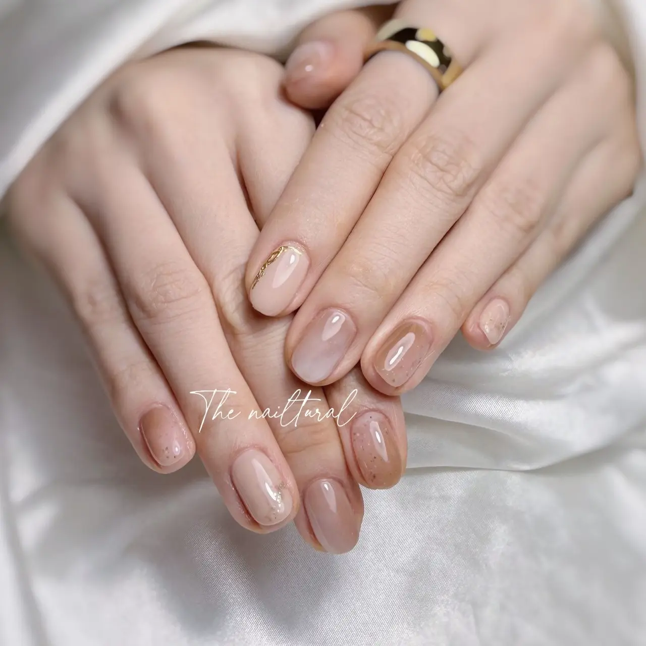 short, neatly manicured , soft tone, neutral tones,  light beige , warm brown.  gold stripe,  natural-looking manicure